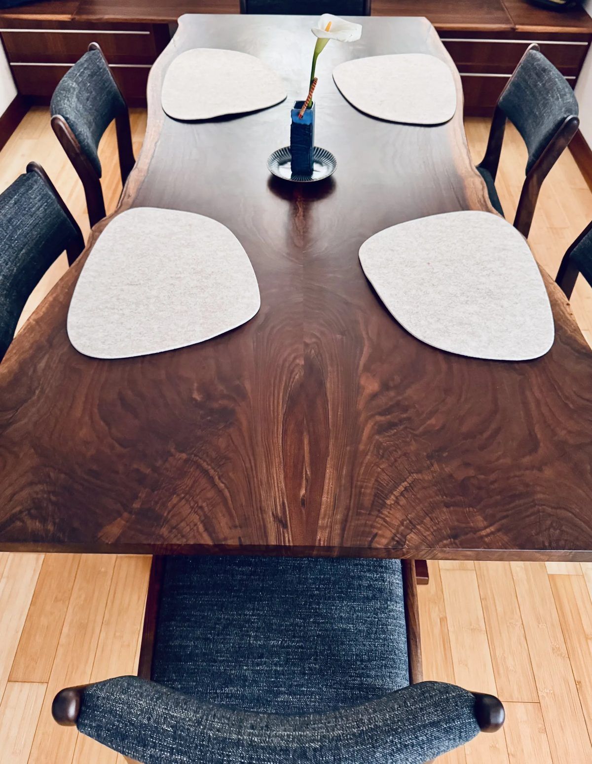 Bookmatched claro walnut dining table with upholstered chairs in a client home